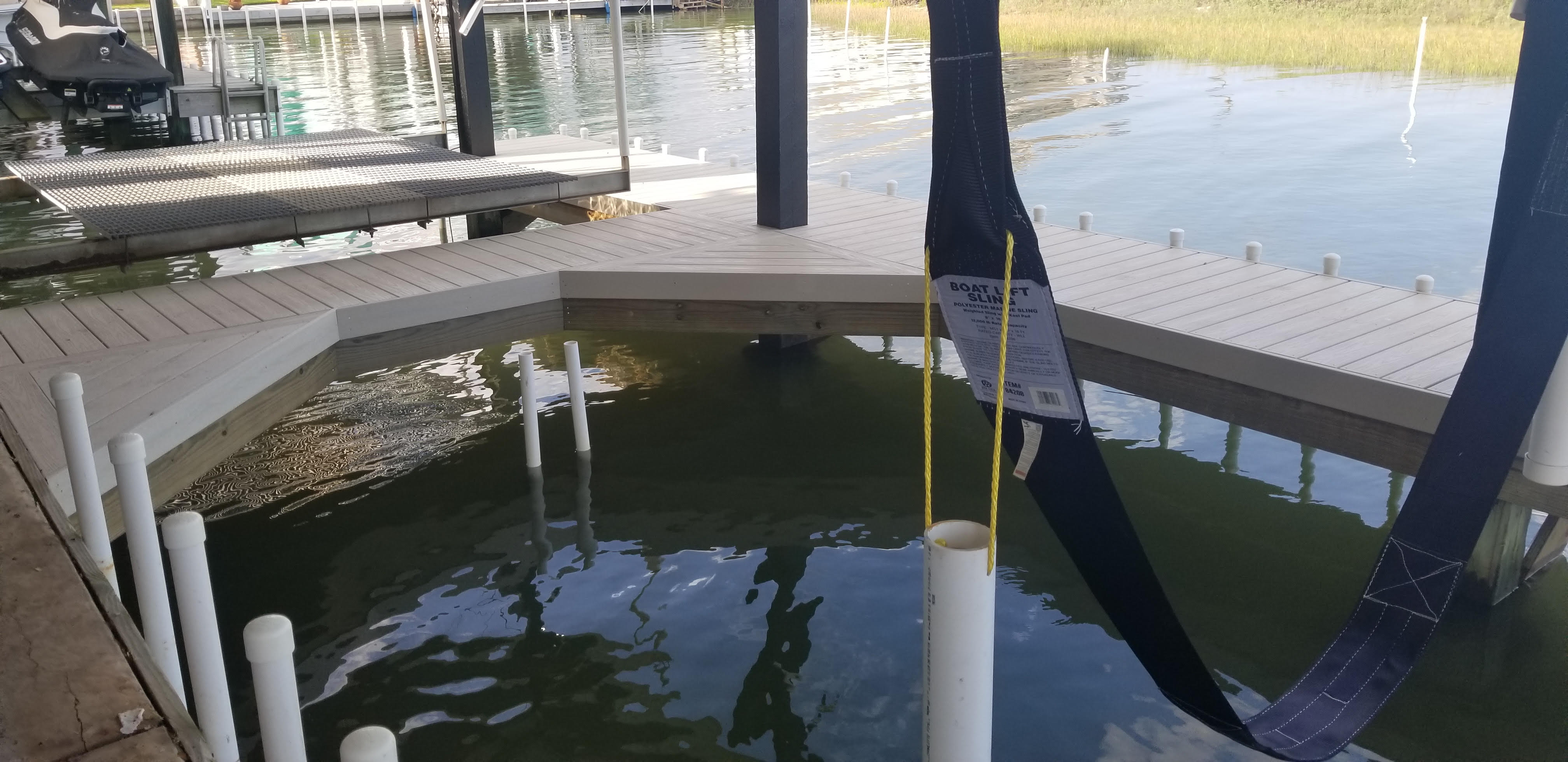 Covered boat dock with a boat lift sling built by Cavalier Custom Decks