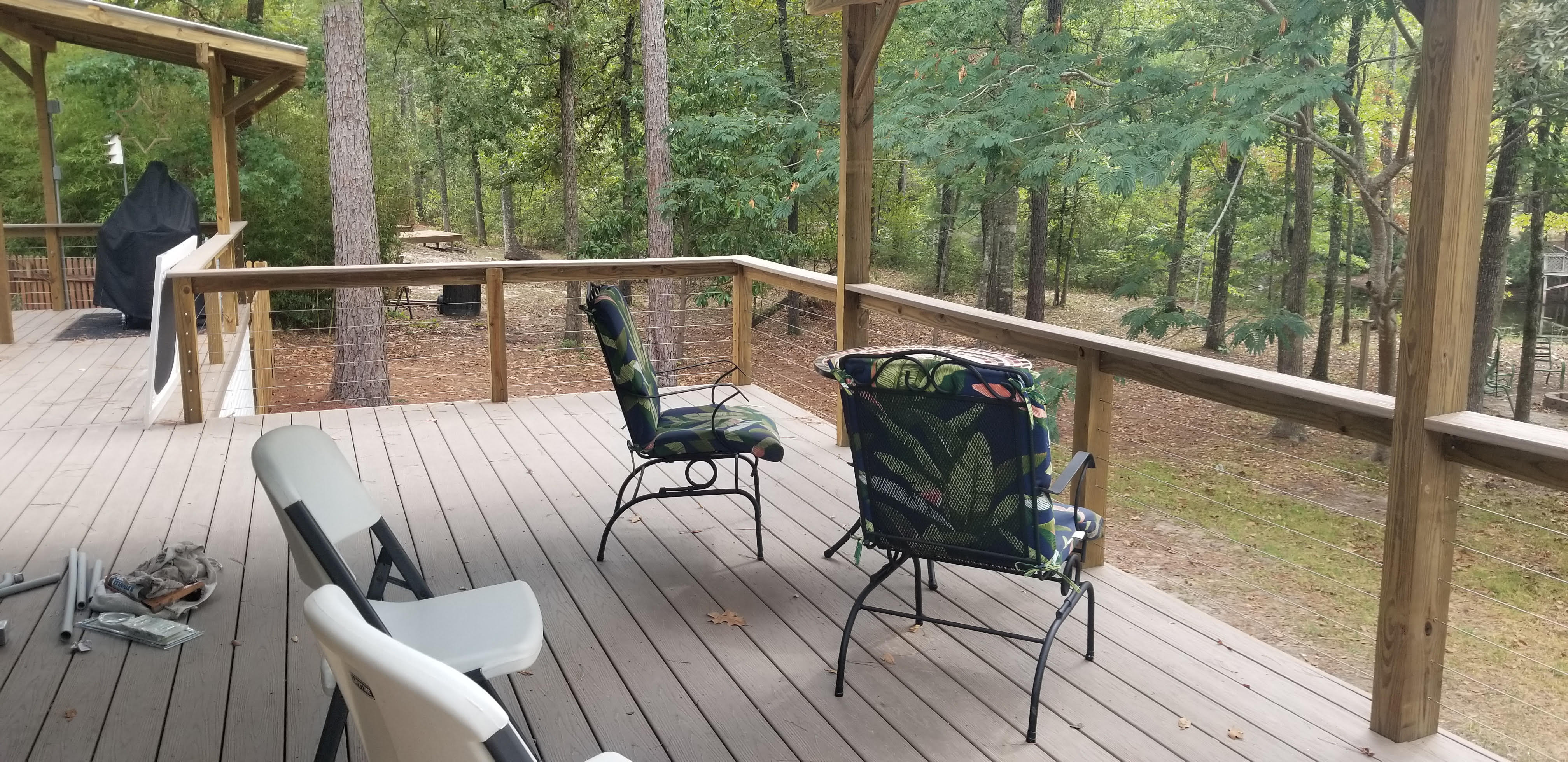 Elevated deck with stainless-steel cable railing built by Cavalier Custom Decks in a wooded East Texas backyard