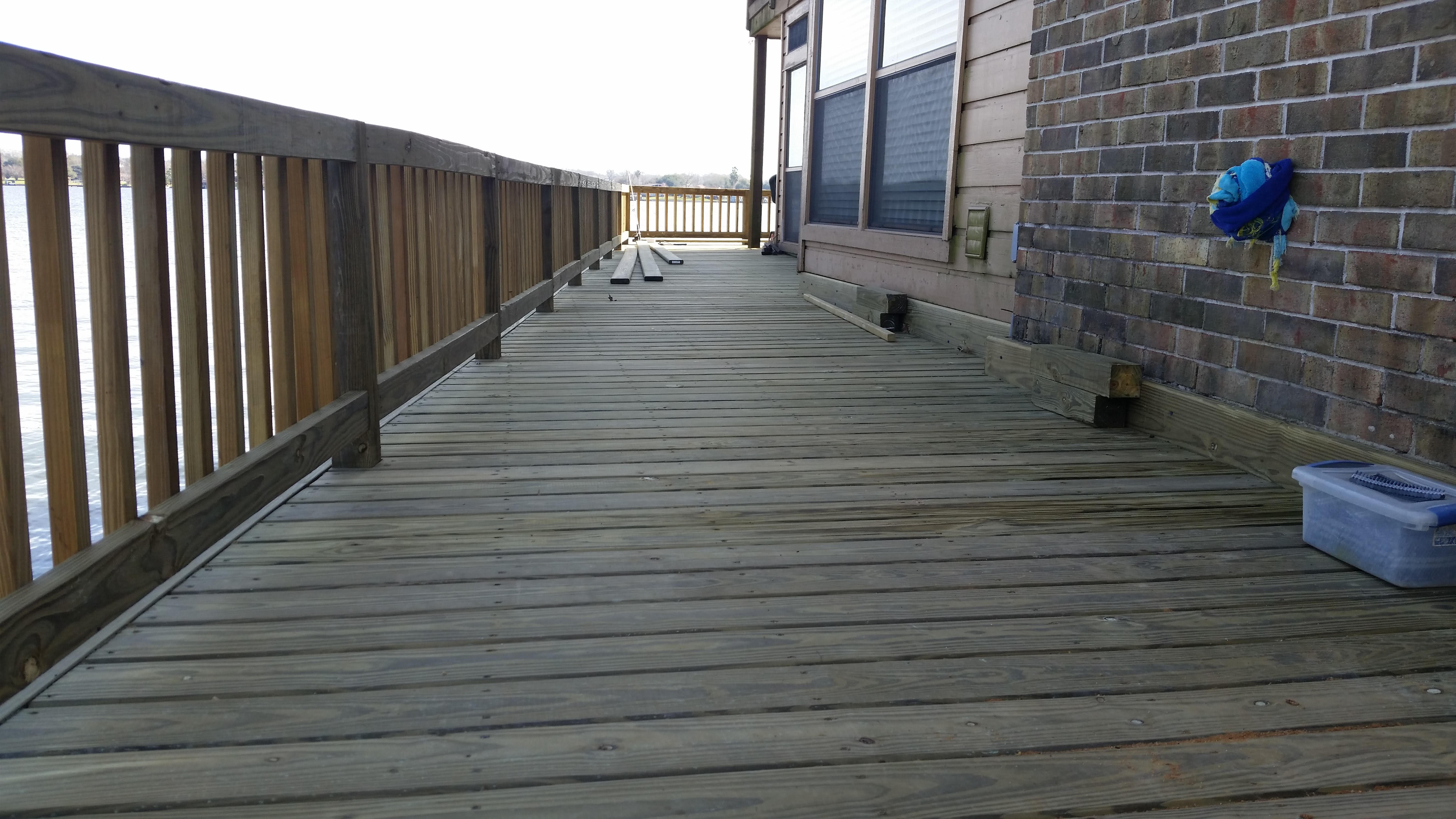 Wood dock walkway with railing built by Cavalier Custom Decks along a Lake Conroe home