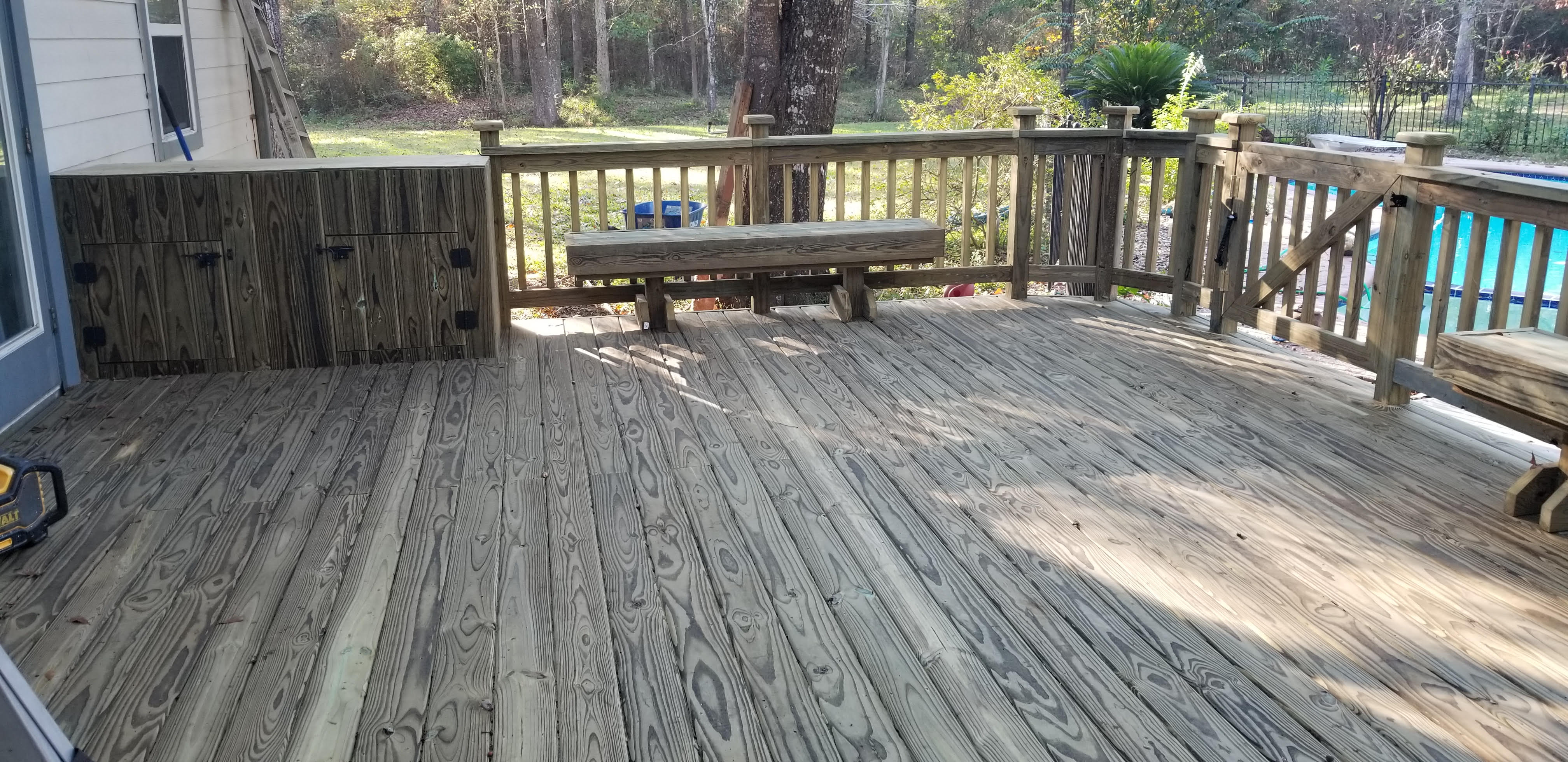 Covered wood deck with built-in storage cabinets and bench built by Cavalier Custom Decks