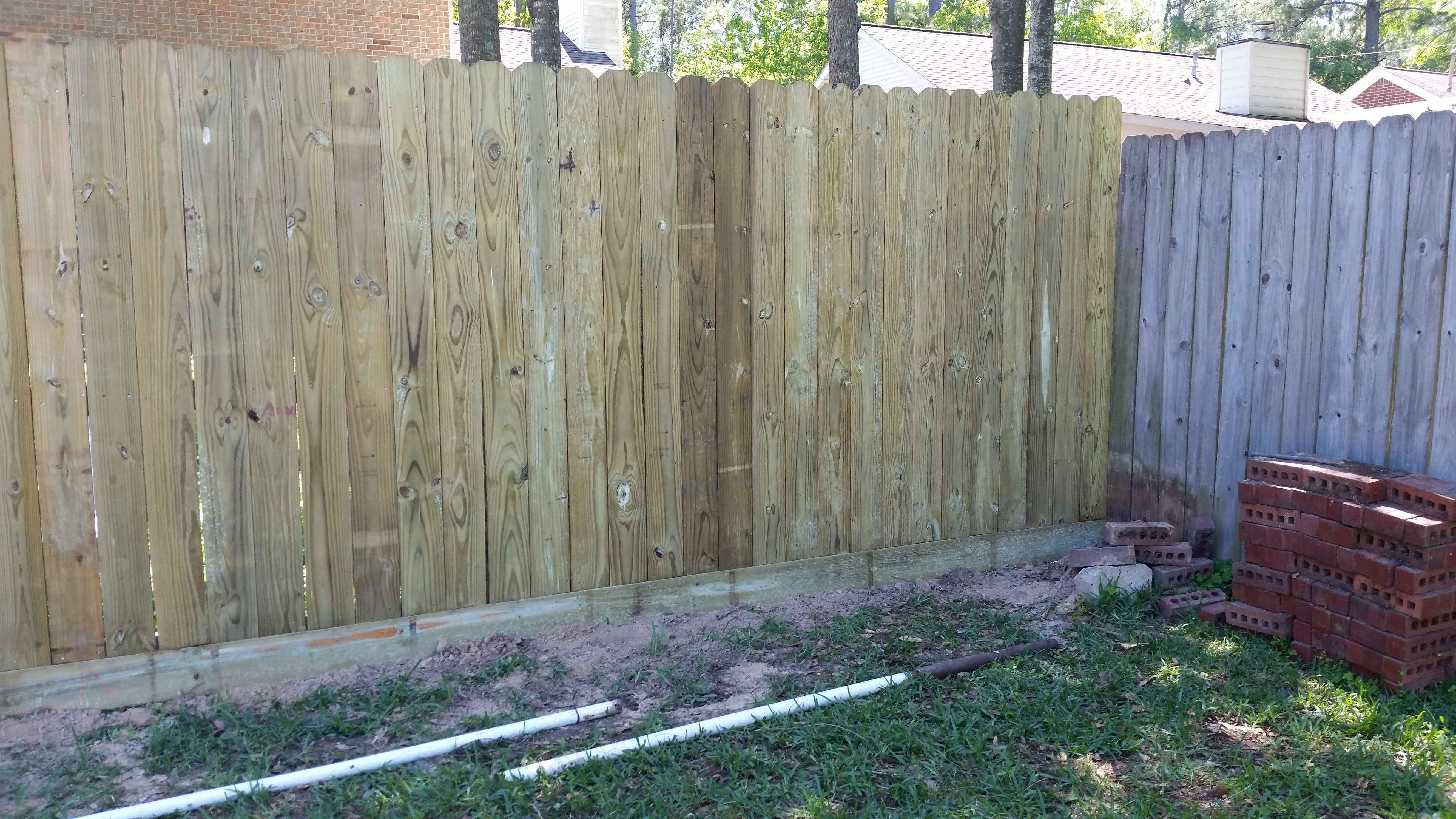 Wood privacy fence built by Cavalier Custom Decks along a brick East Texas home